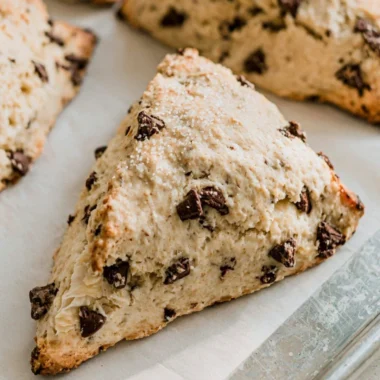 Freshly baked chocolate chip scones on a wooden table