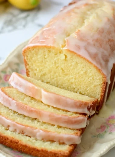 Cozy gluten-free lemon loaf drizzled with a sweet glaze on a wooden table