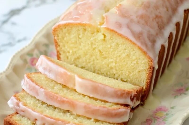 Cozy gluten-free lemon loaf drizzled with a sweet glaze on a wooden table