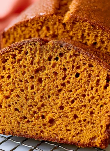 Cozy healthy pumpkin bread loaf filled with spices and served on a rustic wooden table