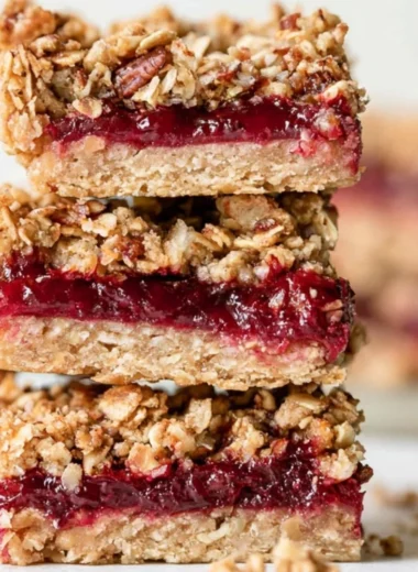 Cozy cranberry sauce oat bars topped with a sprinkle of oats and cranberries