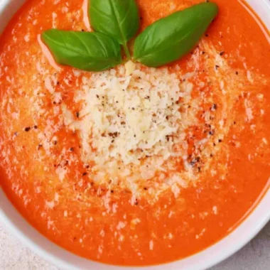 Delicious high protein tomato soup served in a bowl with fresh herbs
