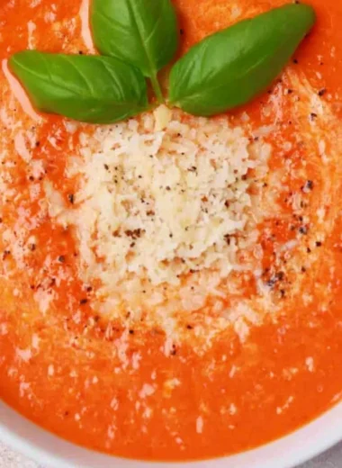 Delicious high protein tomato soup served in a bowl with fresh herbs