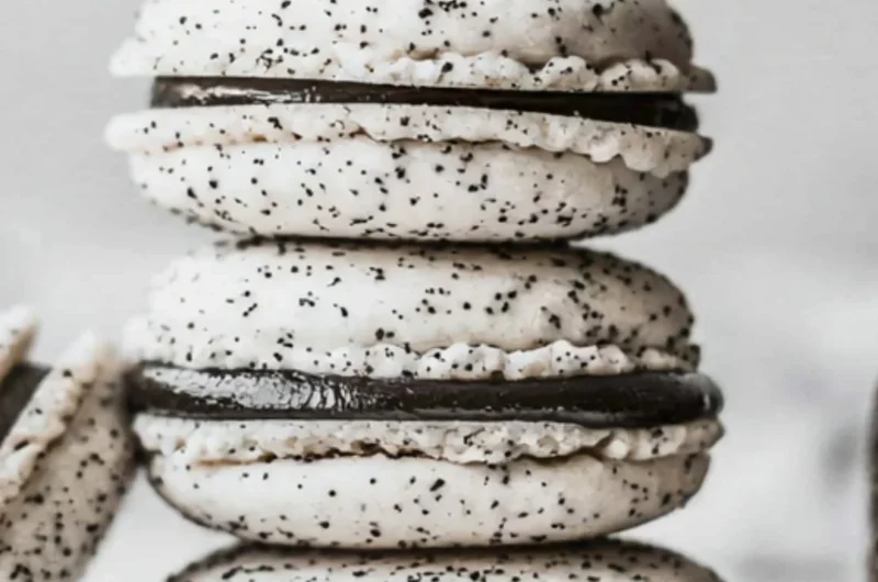 Delicious Oreo Macarons stacked on a plate, featuring chocolate cream filling.