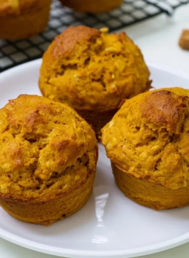 Freshly baked pumpkin oatmeal muffins with a sprinkle of oats and spices