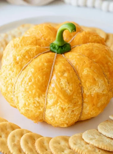 Pumpkin shaped cheese ball appetizer on a serving platter