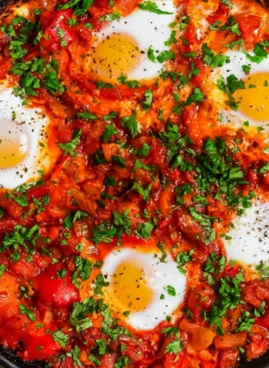 A vibrant serving of Shakshuka with poached eggs in a spicy tomato sauce.