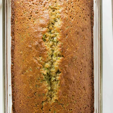 Two slices of moist zucchini bread on a wooden cutting board