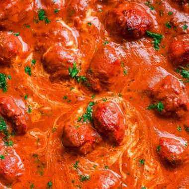 Delicious bowl of chicken tikka masala served with rice and naan bread