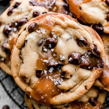 Freshly baked salted caramel chocolate chip cookies on a cooling rack