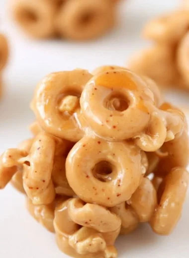 Bowl of peanut butter cereal bites with a spoon on a wooden table