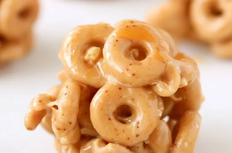 Bowl of peanut butter cereal bites with a spoon on a wooden table