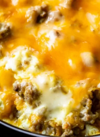 Cheesy sausage hashbrown breakfast casserole served in a baking dish.
