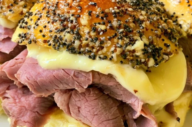 Cozy roast beef sliders served on a rustic wooden platter