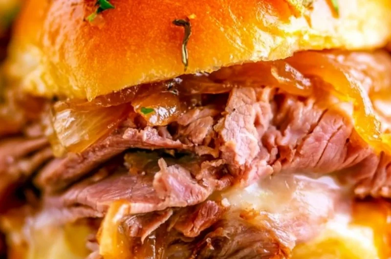 French Dip Sliders with beef and dipping sauce served on a platter
