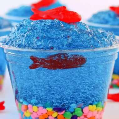 Mini fish tank Jell-O cups with colorful gummy fish and seaweed decorations.