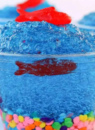 Mini fish tank Jell-O cups with colorful gummy fish and seaweed decorations.