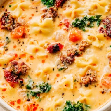 Delicious bowl of warm Italian sausage pasta soup served with fresh herbs.
