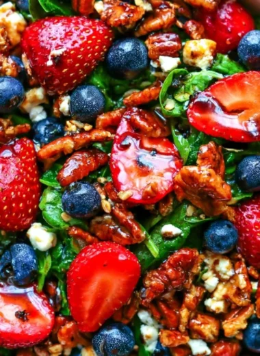 Delicious strawberry spinach salad with blueberries, pecans, and feta cheese in balsamic glaze.