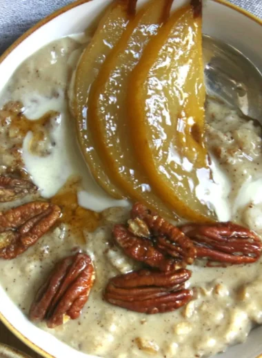Chai spiced pear porridge topped with fresh pears and spices in a bowl