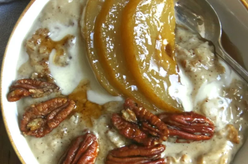 Chai spiced pear porridge topped with fresh pears and spices in a bowl