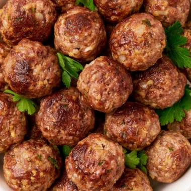 Homemade meatballs prepared and ready for freezing, served with marinara sauce.