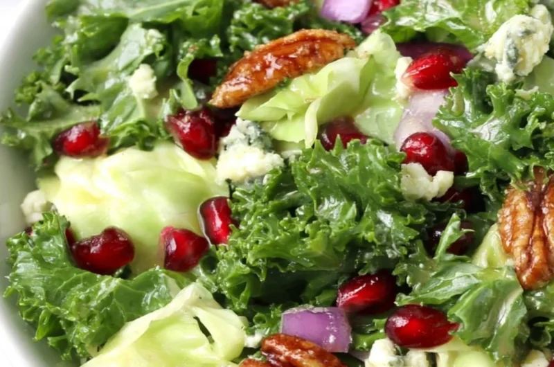 Winter chopped salad featuring pomegranate seeds and blue cheese on a festive table.